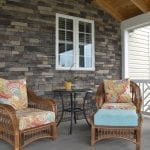 screened-in porch with stone wall