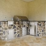 outdoor kitchen matched with a tan house