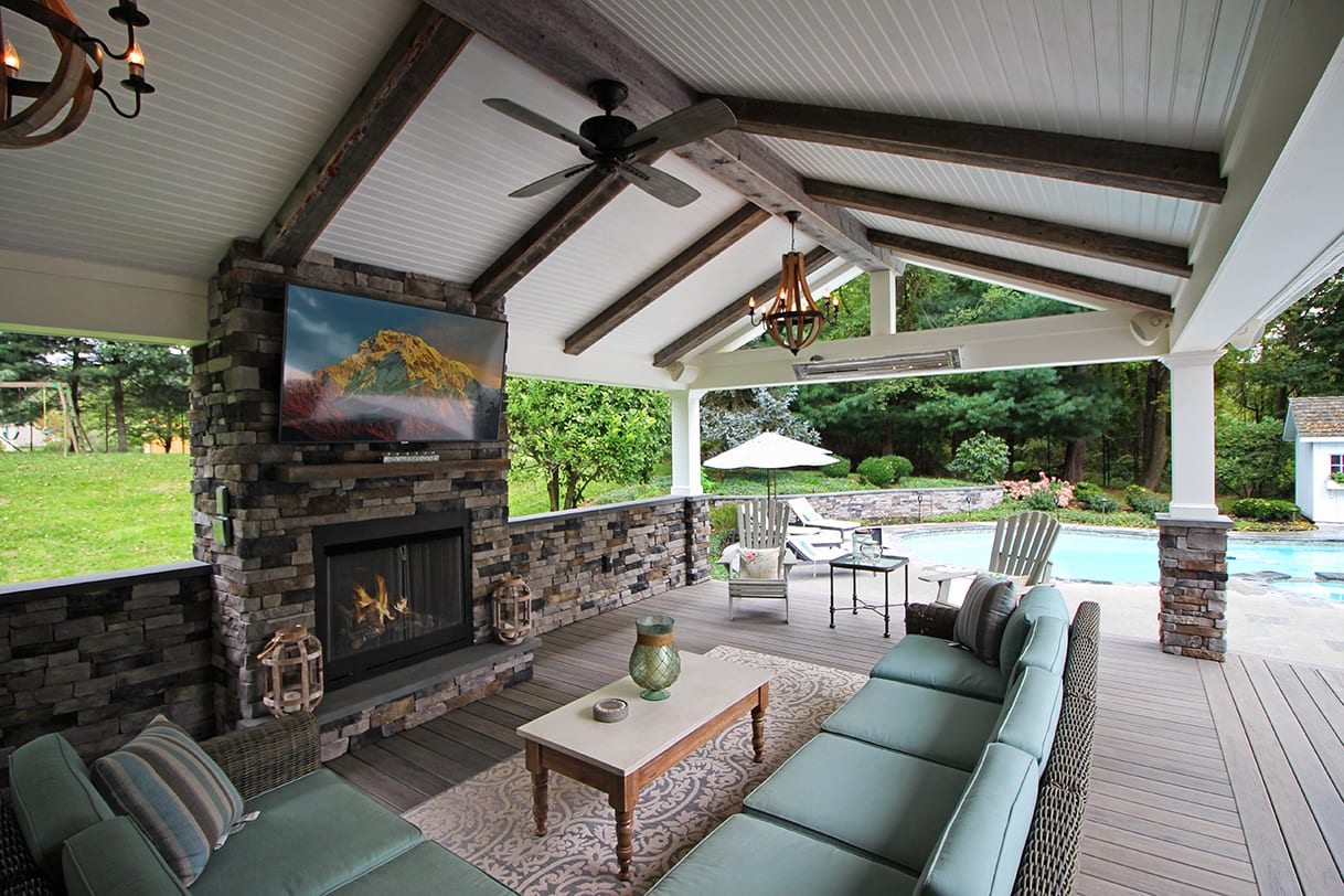 covered porch with fireplace and ceiling fan