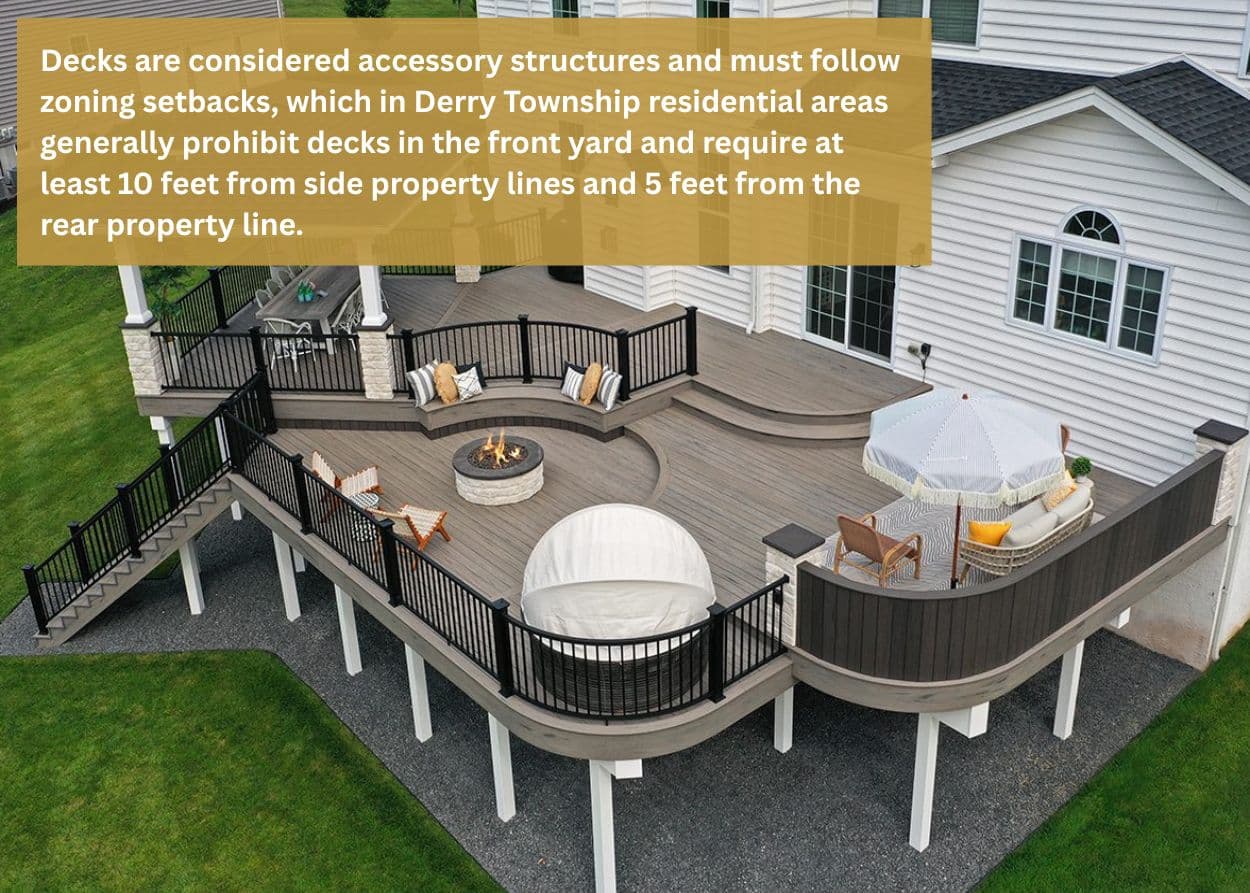 Elevated composite deck with curved seating and railings, showing how zoning and setback requirements impact deck construction in Derry Township, PA. Caption: Decks are considered accessory structures and must follow zoning setbacks, which in Derry Township residential areas generally prohibit decks in the front yard and require at least 10 feet from side property lines and 5 feet from the rear property line.