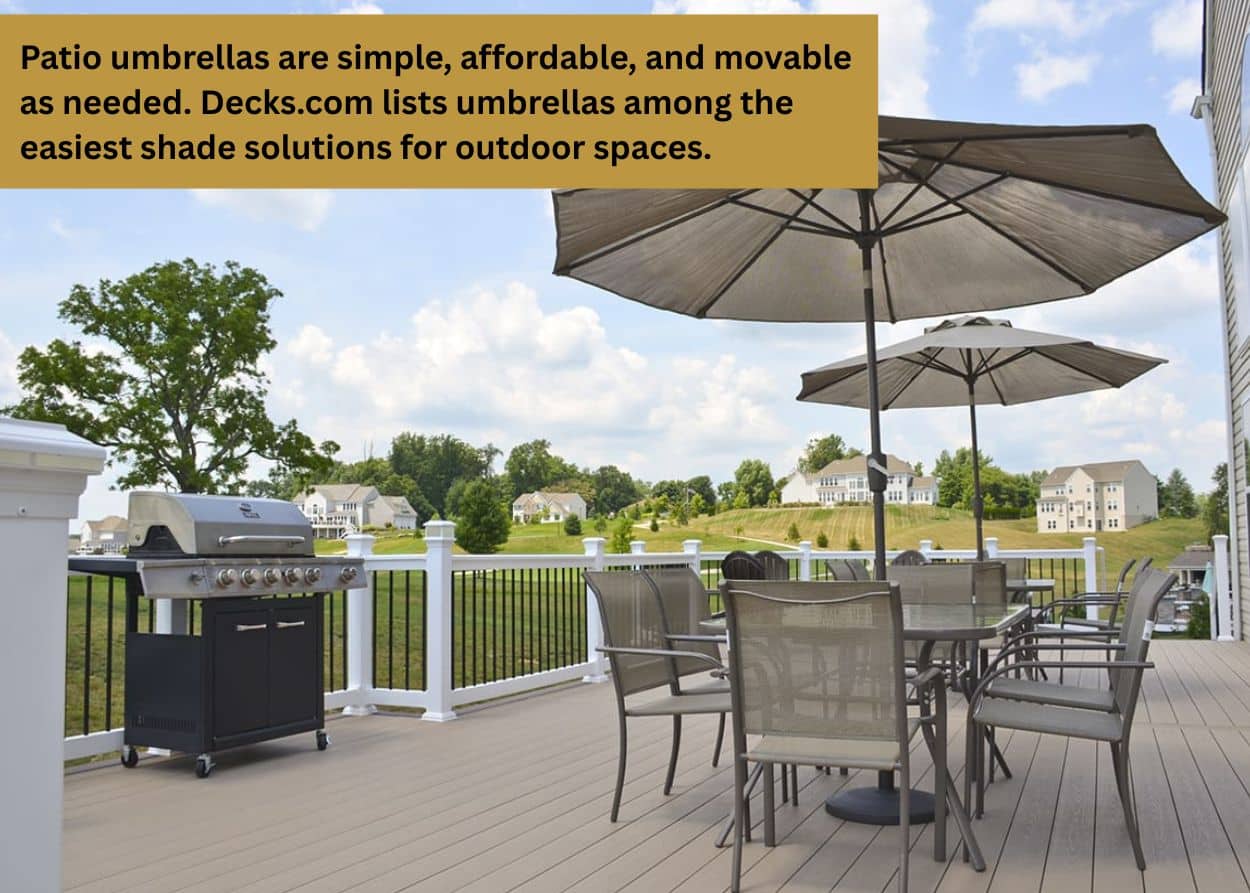 Large patio umbrellas providing shade over an outdoor dining table on a composite backyard deck.