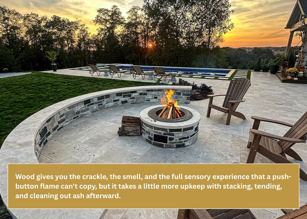 Custom wood-burning fire pit with stone seating wall overlooking a backyard pool at sunset