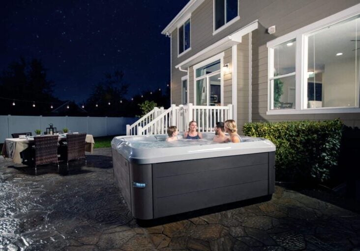 people enjoying an outdoor hot tub at night